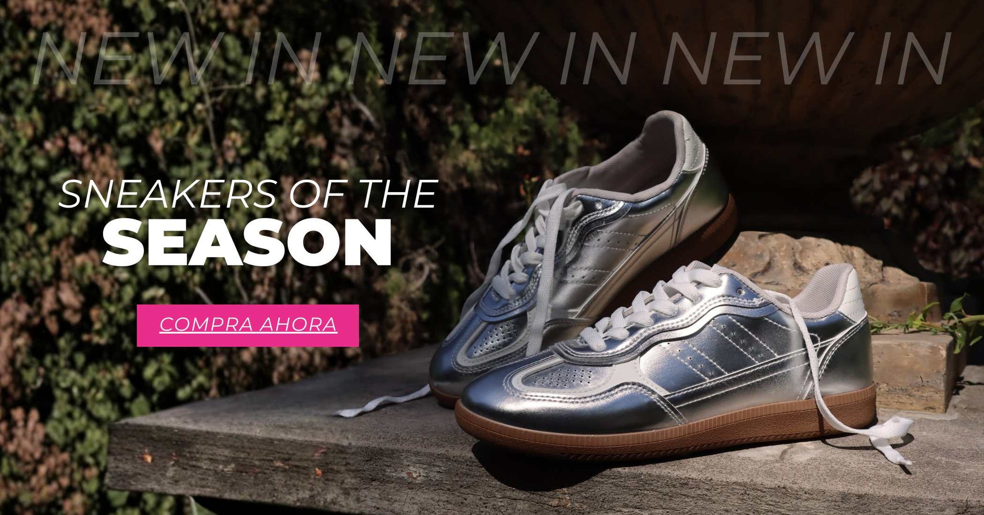 Sneakers plateadas de nueva temporada para mujer sobre mesa de piedra con mensaje New In sneakers of the season